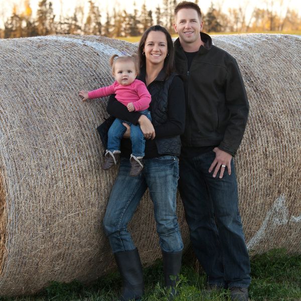 Young Farming Family Next To Hay Stack